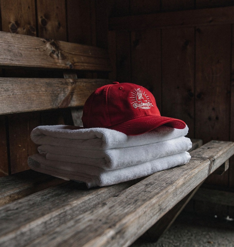 Badmeister Accessoires — Cap auf weissen Handtüchern in Badi-Kabine